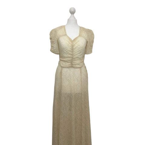 original 1930s sheer ivory lace dress on a mannequin against a white background