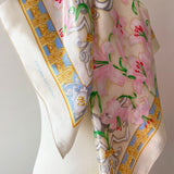 Floral Pierre Balmain vintage satin scarf with decorative border and pink lily print on a mannequin against a white background