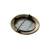 antique brass framed brooch on white background