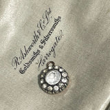 round antique Georgian pendant with one central large paste stone surrounded by 12 small ones on satin jewellery box background. Available via hurdyburdy vintage shop