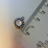 ruler alongside a 1cm round antique Georgian pendant with one central large paste stone surrounded by 12 small ones on white background. Available via hurdyburdy vintage shop