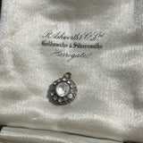 round antique Georgian pendant with one central large paste stone surrounded by 12 small ones on satin jewellery box background. Available via hurdyburdy vintage shop