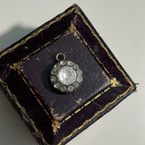round antique Georgian pendant with one central large paste stone surrounded by 12 small ones on brown and gold old jewellery box. Available via hurdyburdy vintage shop