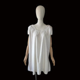 antique white cotton chemise on a mannequin against a black background