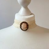 Necklace with cameo brooch or pendant on a mannequin bust against a plain background