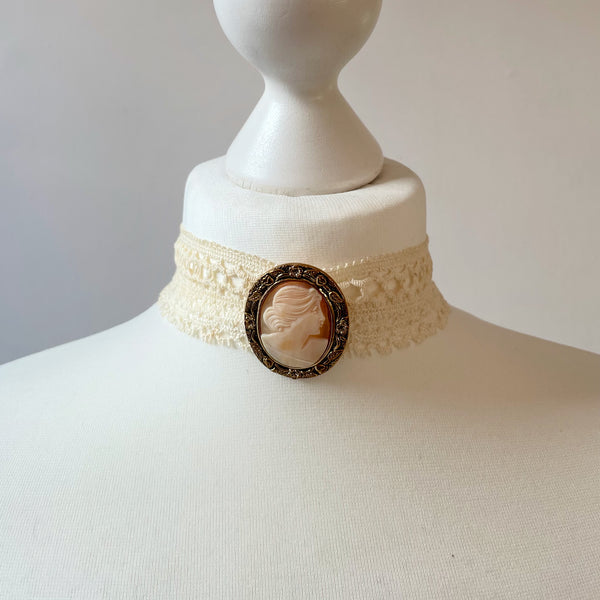 Necklace with cameo brooch or pendant on a mannequin bust against a plain background
