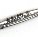 vintage silver brooch decorated with a black enamel palm tree riverside scene. hurdyburdy vintage
